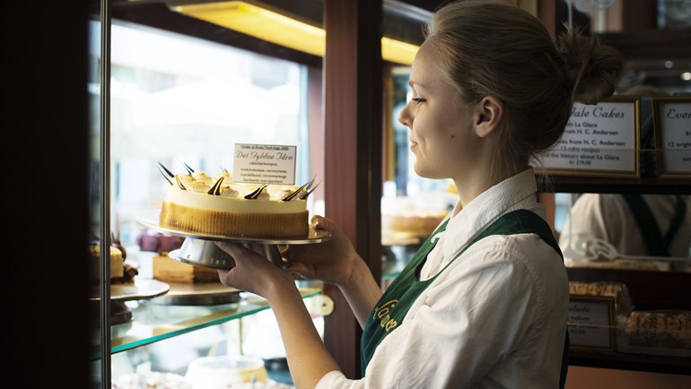 Pige der sætter en kage i udstillingsvinduet på La Glace | Photo by: Robin Skjoldborg | Source: Visit Denmark